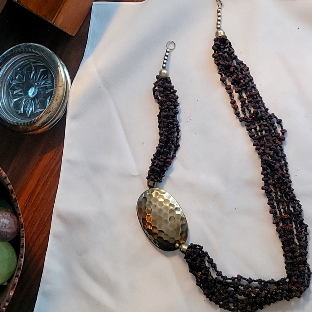 Unusual peppercorn and glass bead necklace with large off centre brass medallion
